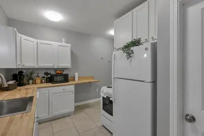 a kitchen with white cabinets and a white refrigerator at Modern 2BR Yale Townhouse Near Downtown Columbus in Columbus