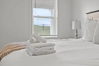 a pile of towels on a bed with a window at Creekside Stay | Peaceful Cottage | Elkhorn in Georgetown