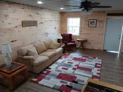a living room with a couch and a wooden wall at A Million Dollar View in Owenton