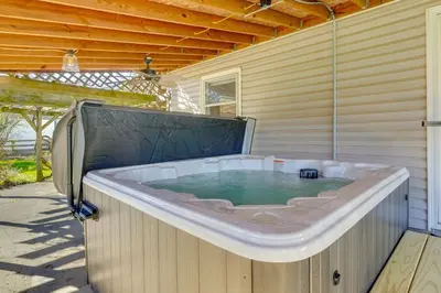 a large bath tub on the side of a house at Hocking Hills Hideaway with Hot Tub and Games in Rockbridge