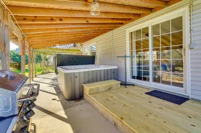 a porch with a hot tub on the side of a house at Hocking Hills Hideaway with Hot Tub and Games in Rockbridge