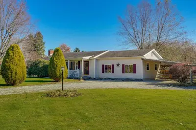 a white house with red windows and a yard at Hocking Hills Hideaway with Hot Tub and Games in Rockbridge
