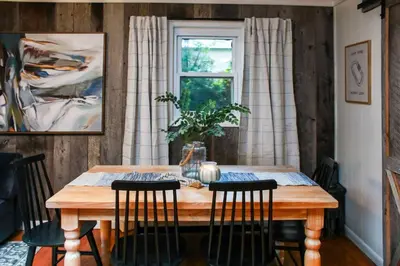 a dining room table with chairs and a window at Alice Rocks - Pet Friendly, Firepit, WiFi in Frenchburg