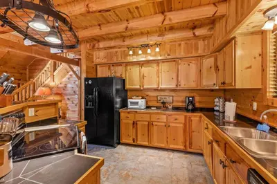 a kitchen with wooden cabinets and a black refrigerator at Starry Mountain Night- Private Pool, Pool Table in Stanton