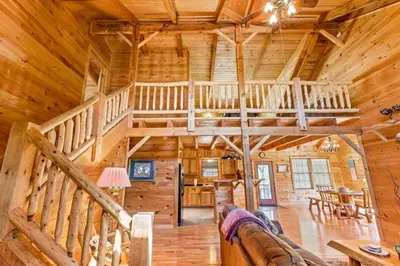 a living room with a staircase in a log cabin at Starry Mountain Night- Private Pool, Pool Table in Stanton