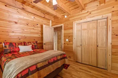 a bedroom with a bed in a log cabin at Starry Mountain Night- Private Pool, Pool Table in Stanton
