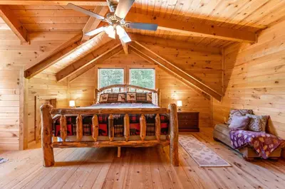 a bedroom with a bed in a log cabin at Starry Mountain Night- Private Pool, Pool Table in Stanton