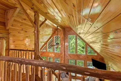 a log cabin with a large wooden ceiling at Birdsong- Hot Tub, Game Room, Firepit, WiFi in Stanton