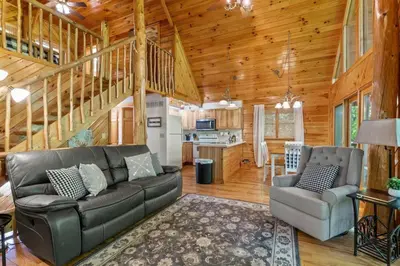 a living room with a couch and chairs in a cabin at Birdsong- Hot Tub, Game Room, Firepit, WiFi in Stanton