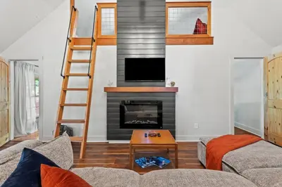 a living room with a fireplace and a ladder at Furnace Mountain Retreat- Hot Tub, Fireplace, WiFi in Stanton