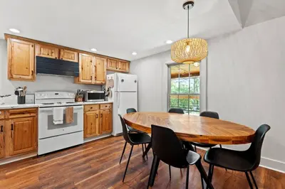 a kitchen with a wooden table and black chairs at Furnace Mountain Retreat- Hot Tub, Fireplace, WiFi in Stanton