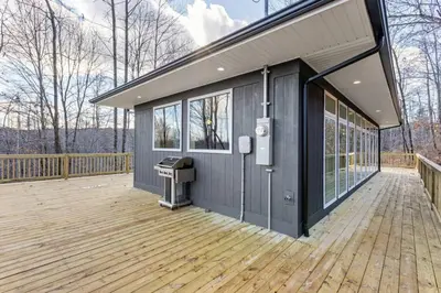 a house with a deck with a trash can at Primrose- Hot Tub, Firepit, Wraparound Deck, WiFi in Wellington