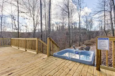 a hot tub on a wooden deck with a sign at Primrose- Hot Tub, Firepit, Wraparound Deck, WiFi in Wellington