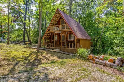 a log cabin in the woods with trees at Sugar Shack - Cave Run Lake OR Red River Gorge KY in Wellington