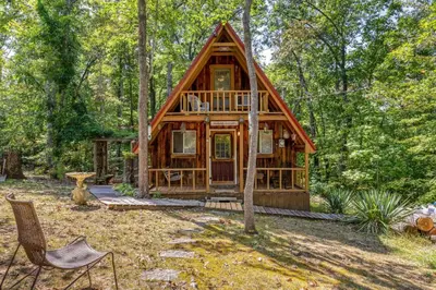 a cabin in the woods with a chair and a tree at Sugar Shack - Cave Run Lake OR Red River Gorge KY in Wellington