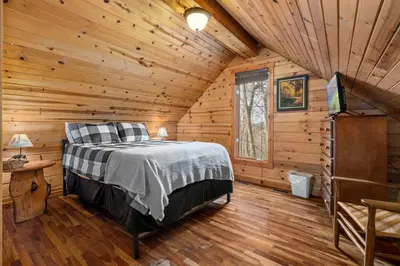 a bedroom with a bed in a log cabin at Beary Cozy- No Pet Fee, Hot Tub, Fireplace, WiFi in Slade