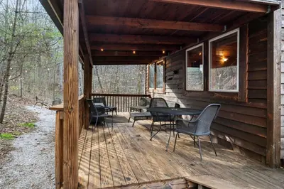 a wooden deck with chairs and a table on it at Beary Cozy- No Pet Fee, Hot Tub, Fireplace, WiFi in Slade