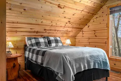 a bedroom with a bed in a wooden cabin at Beary Cozy- No Pet Fee, Hot Tub, Fireplace, WiFi in Slade