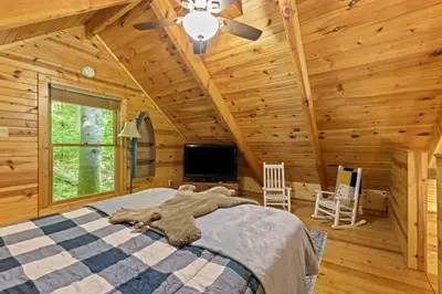 a bedroom with a bed in a log cabin at Beary Secluded- No Pet Fee, Hot Tub, Firepit, WiFi in Slade