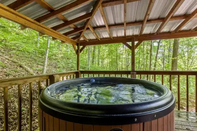 a hot tub on a deck with a roof at Beary Secluded- No Pet Fee, Hot Tub, Firepit, WiFi in Slade