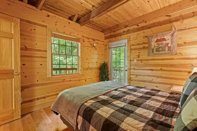a bedroom with a bed in a log cabin at Beary Secluded- No Pet Fee, Hot Tub, Firepit, WiFi in Slade