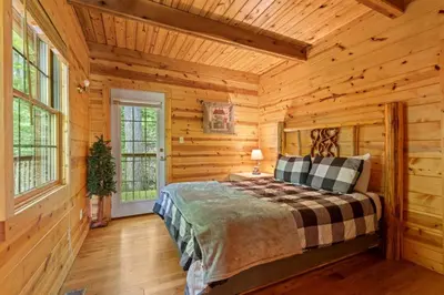 a bedroom with a bed in a log cabin at Beary Secluded- No Pet Fee, Hot Tub, Firepit, WiFi in Slade
