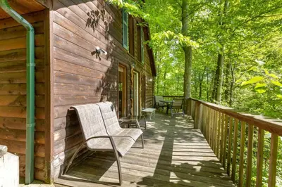 a wooden deck with a bench on the side of a house at Beary Secluded- No Pet Fee, Hot Tub, Firepit, WiFi in Slade