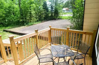 a porch with three chairs and a table on it at A Frame of Mind - near Red River Gorge KY in Jeffersonville