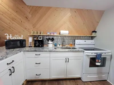a kitchen with white cabinets and a wooden ceiling at A Frame of Mind - near Red River Gorge KY in Jeffersonville