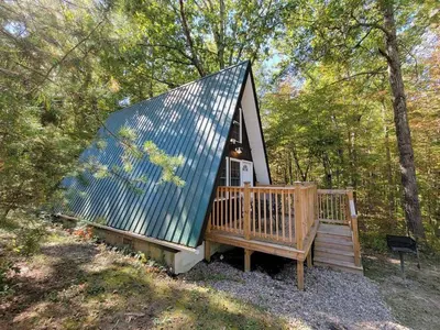 a small cabin in the woods with a blue roof at A Frame of Mind - near Red River Gorge KY in Jeffersonville