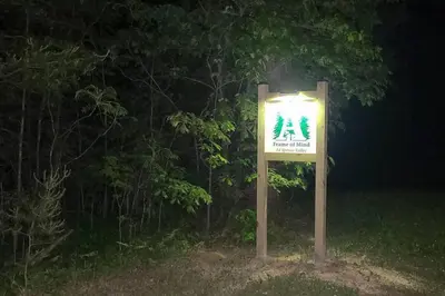 a sign in front of a tree at night at A Frame of Mind - near Red River Gorge KY in Jeffersonville