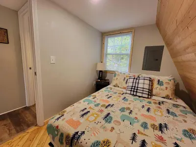 a bedroom with a bed with a comforter on it at A Frame of Mind - near Red River Gorge KY in Jeffersonville