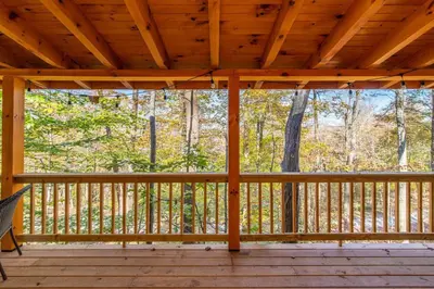 a screened in porch of a cabin with a wooden ceiling at Cozy Canopy- Hot Tub, Firepit, Covered Deck, WiFi in Stanton