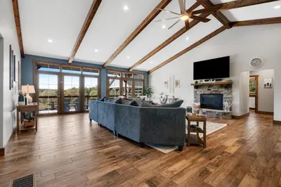 a living room with a large couch and a fireplace at Calaboose Retreat- Hot Tub , Pool Table, Fireplace in Campton