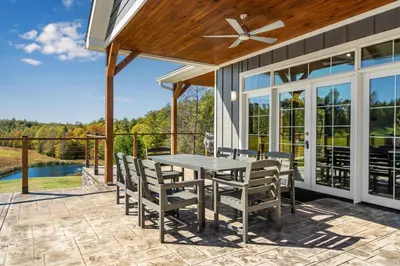 a patio with a table and chairs and a ceiling fan at Calaboose Retreat- Hot Tub , Pool Table, Fireplace in Campton