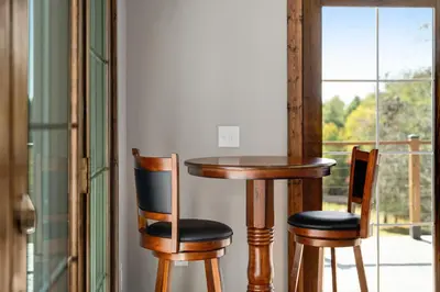 a table and two chairs in front of a window at Calaboose Retreat- Hot Tub , Pool Table, Fireplace in Campton