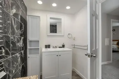a white bathroom with a sink and a mirror at Cozy and stylish 3BR home in quiet neighborhood in Cleveland