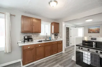 a kitchen with wooden cabinets and a stove top oven at Cozy and stylish 3BR home in quiet neighborhood in Cleveland