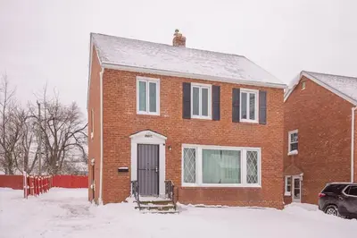 a red brick house with a door in the snow at Cozy and stylish 3BR home in quiet neighborhood in Cleveland