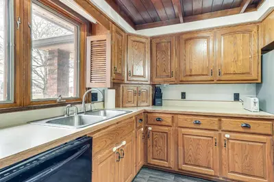 a kitchen with wooden cabinets and a sink and a window at Woodburn Group Getaway Endless On-Site Fun! in Woodburn
