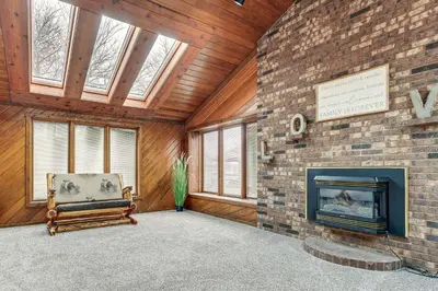 a living room with a fireplace and a chair at Woodburn Group Getaway Endless On-Site Fun! in Woodburn
