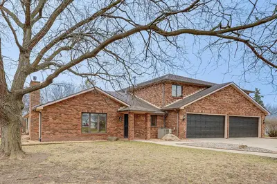 a brick house with a garage and a tree at Woodburn Group Getaway Endless On-Site Fun! in Woodburn