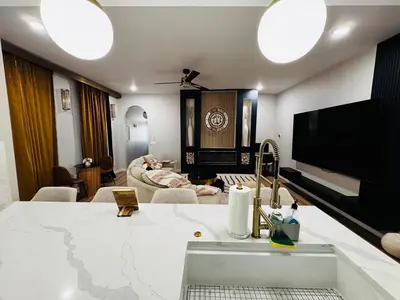 a kitchen with a sink and a living room at Downtown Cincinnati Boutique at Newport 3BR with 100in Cinema TV in Dayton