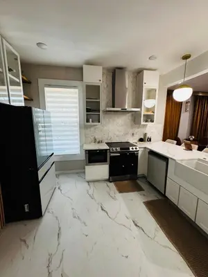 a large kitchen with white marble floors and appliances at Downtown Cincinnati Boutique at Newport 3BR with 100in Cinema TV in Dayton