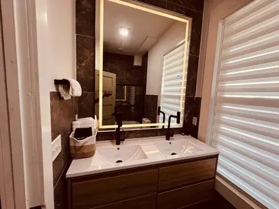 a bathroom with a sink and a large mirror at Downtown Cincinnati Boutique at Newport 3BR with 100in Cinema TV in Dayton