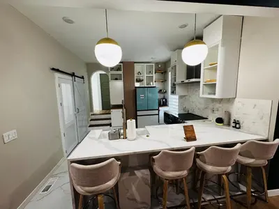a kitchen with a large island with bar stools at Downtown Cincinnati Boutique at Newport 3BR with 100in Cinema TV in Dayton