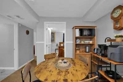 a dining room with a wooden table and a kitchen at The Little Paradise in Morrow