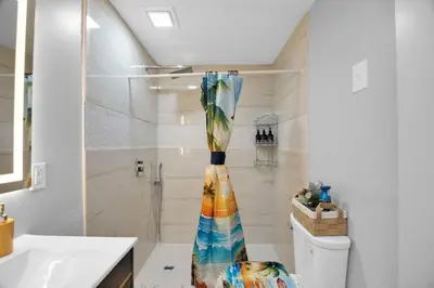 a bathroom with a shower and a vase on the counter at The Little Paradise in Morrow
