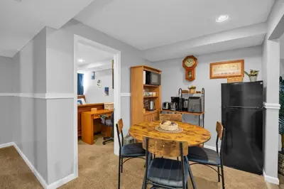 a dining room with a table and a black refrigerator at The Little Paradise in Morrow