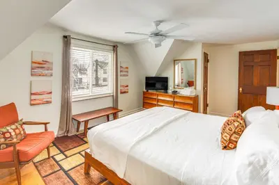a bedroom with a large white bed and a chair at Bring the Family! Mid-Century Modern Gem in Euclid in Euclid